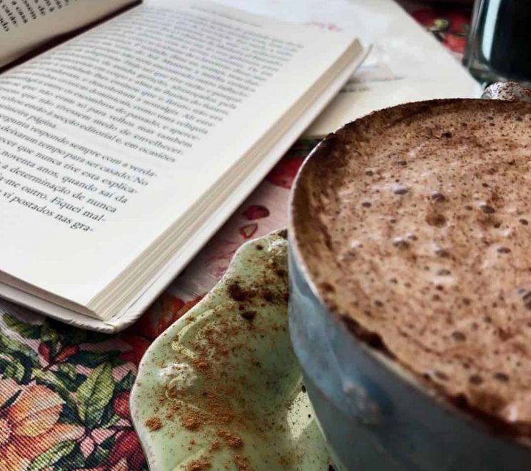 capuccino e um livro na mesa do chá e bolachas- cafetaria para visitar em Aveiro